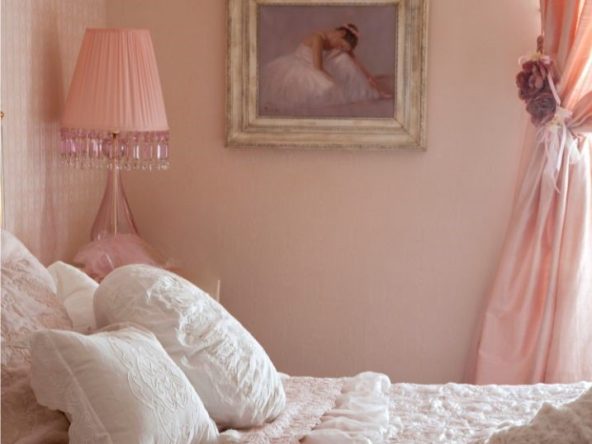 Coquette Chic: a bed with pink ruffled blankets and lacy pillows. Pink walls and pink curtains. There is a painting of a ballerina in a gold mirror.
