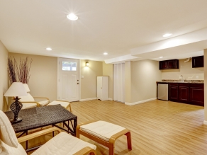 Bright room with new hardwood floor and ivory walls. Tropical style furniture set with dry branches in the conrner. VIew of kitchen area with dark brown cabinets. Mother-in-law apartment